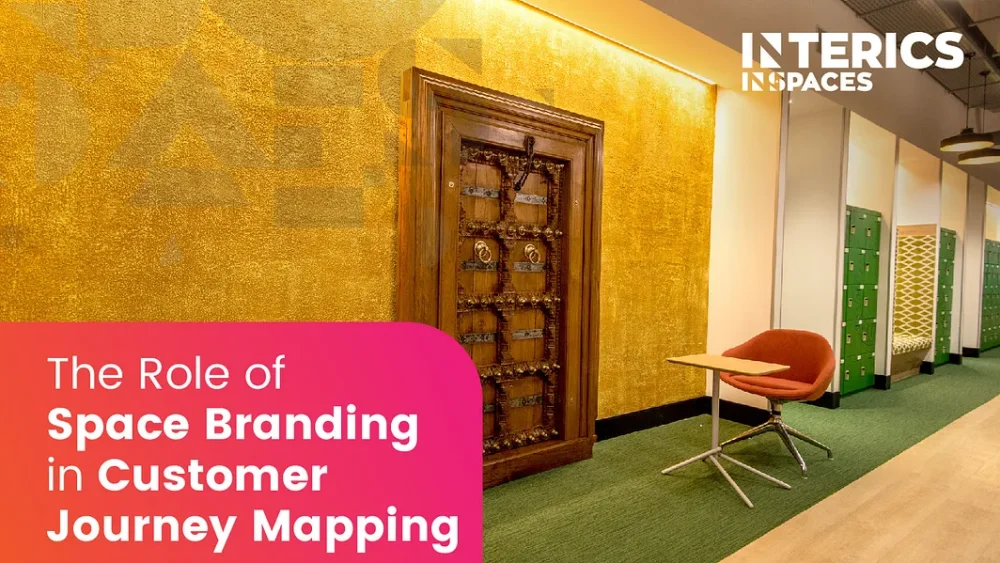 Modern office interior with gold textured feature wall, wooden decorative door, green lockers, and branded workspace by Interics InSpaces