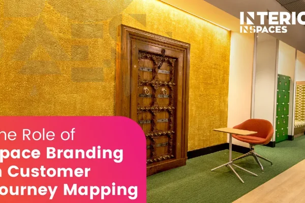 Modern office interior with gold textured feature wall, wooden decorative door, green lockers, and branded workspace by Interics InSpaces