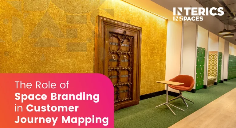 Modern office interior with gold textured feature wall, wooden decorative door, green lockers, and branded workspace by Interics InSpaces